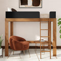 Modern wooden loft bed with black guardrails and ladder above a cozy rust-colored armchair and round side table in a styled bedroom