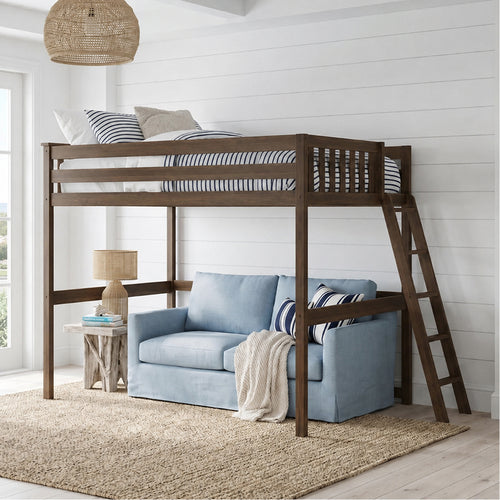 Wooden loft bed with a blue sofa underneath in a bright room.