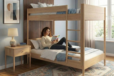 Sunlit bedroom with modern light-wood bunk bed, ladder and bedside table, person reading on lower bed with cozy bedding