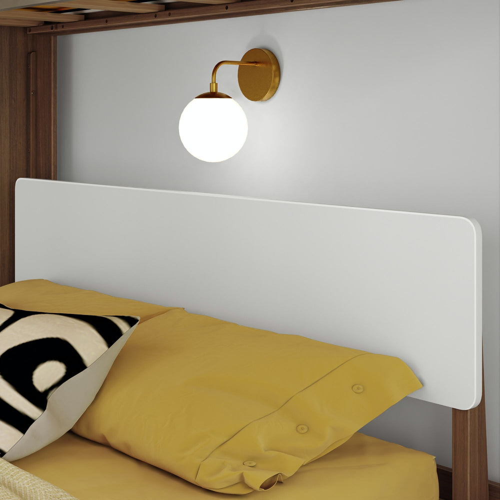 Modern bedroom with yellow bedding and wall-mounted globe lamp near headboard.