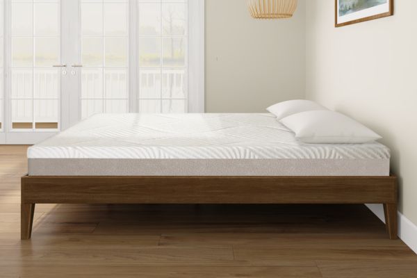 Mattress on a wooden bed frame in a room with light-colored walls and flooring.