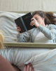 Adults hanging out around their bunk beds and smiling.