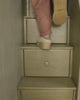 Different scenes of adults climbing the stairs of a bunk, a woman sleeping on a top bunk, and groups of adults sitting on the bottom of a large wooden bunk bed talking.